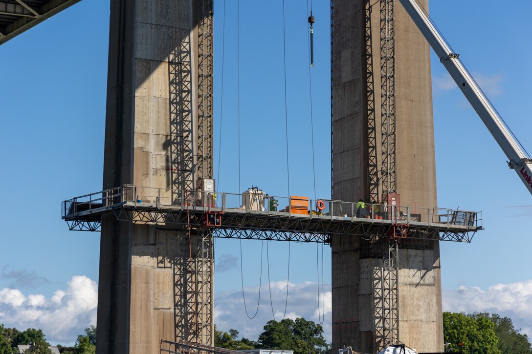 Crane and suspended access platform beside concrete bridge piers at St. Georges Bridge, Delaware